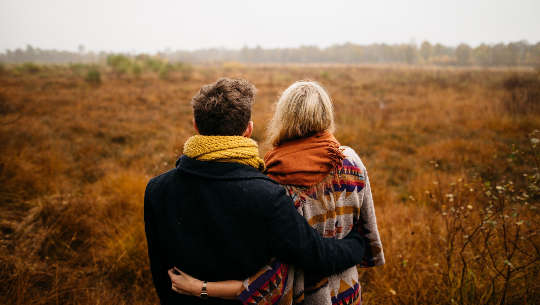 couple out in nature with their arms around each other's waists