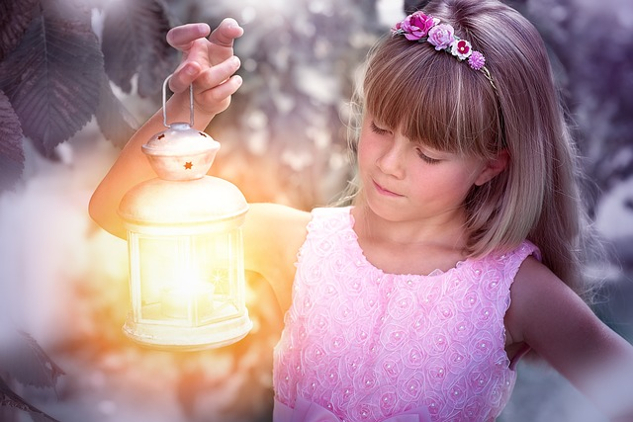 a girl holding up a brightly shining lantern
