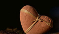 a heart made of stone with a ribbon around it